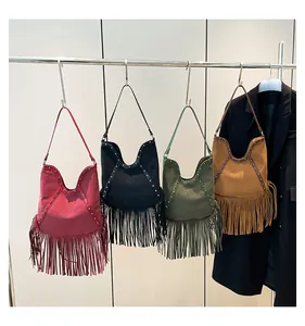 Detailed view of four vintage bohemian fringe tote bags hanging in various colors.