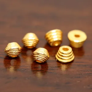 Macro detail of gold-plated silver spacer beads with spiral engraved texture