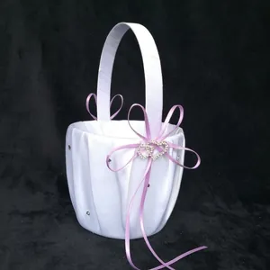 Close-up of white satin wedding basket featuring lavender bow and sparkling heart crystals