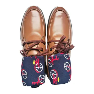 Close-up detail of stylish bicycle pattern mid-calf cotton socks in brown leather shoes.