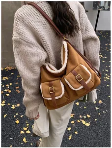 Brown suede-like fleece-lined shoulder bag being carried by a model wearing a chunky sweater.