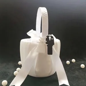 Elegant white satin wedding flower girl basket with tuxedo and bridal gown charms