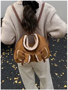 Stylish brown suede backpack with white faux fur trim shown on model back for winter.