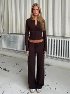 Vista completa di un set da donna con cardigan in maglia marrone scuro e pantaloni larghi.