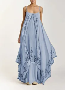 Détail d'une robe longue bohème bleu clair à fleurs avec des bretelles spaghetti