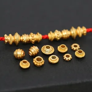 Close-up of S925 gold-plated spacer beads with various textured patterns for DIY jewelry
