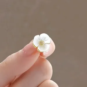Close-up of elegant flower brooch pin with mother-of-pearl petals and gold finish