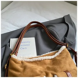 Detail of a brown suede tote bag with white fleece trim and brown leather straps