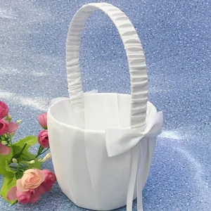 Detailed close-up of the elegant pleated satin wedding flower girl basket with a bow
