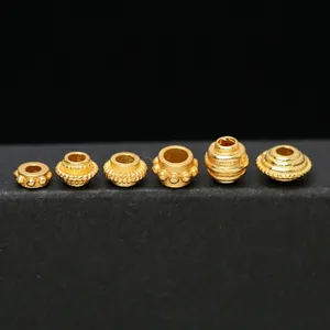 Detailed close-up of S925 gold-plated silver spacer beads with various engraved patterns