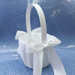 Detailed view of white satin wedding flower girl basket with large elegant bow