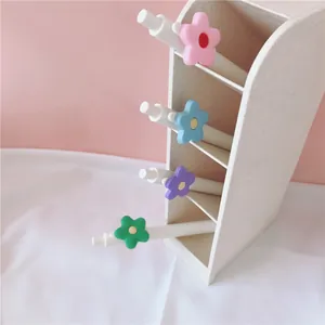 Set of four white 0.5mm black gel pens with colorful flower-shaped clips for school.