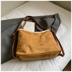 Detailed macro view of a stylish brown suede tote bag featuring soft white plush trim.