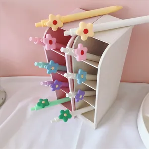 Pastel gel pens with cute flower clips arranged in a desktop organizer