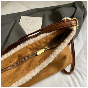 Detail shot of a winter suede tote bag with white faux fur trim and gold zipper.
