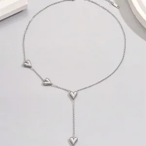 Detail view of a silver stainless steel necklace with multiple heart pendants.