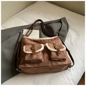 Close-up of stylish brown suede shoulder bag featuring white faux fur trim details