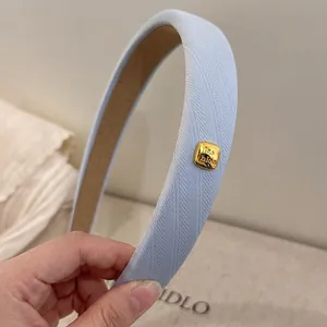 Stylish light blue padded sponge headband with decorative golden fashion buckle detail