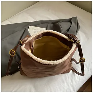 Detailed interior view of a brown suede backpack with cream fleece trim and zipper pocket
