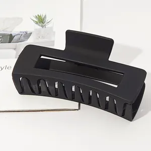Detailed view of a matte black rectangular hair claw clip, ideal for thick hair styling