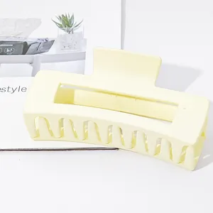 Detail showing texture of a large rectangular matte yellow hair claw clip for thick hair