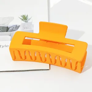 Large matte orange rectangular hair claw clip for thick hair styling.