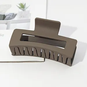 Close-up of a large matte brown rectangular hair claw clip featuring a shark clip design