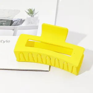 Detail view of a large vibrant yellow matte rectangular hair claw clip for thick hair
