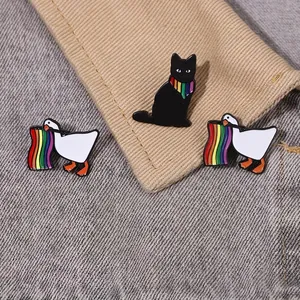 Detailed macro shot of cute cartoon black cat and white goose enamel pins on denim jacket