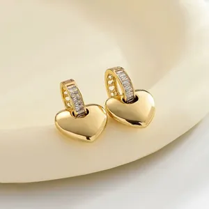 Elegant close-up of gold-plated heart drop earrings with clear cubic zircon stones