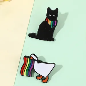 Close-up of cute cartoon cat and duck enamel pins with rainbow pride elements