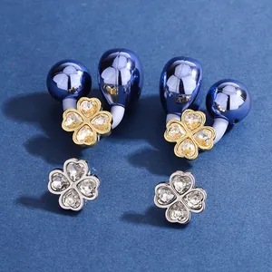 Macro view of four-leaf clover rhinestone clips for Bluetooth earphones accessories.