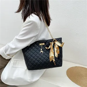 Stylish black quilted shoulder bag featuring gold chain strap and decorative scarf.
