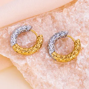 Détail de boucles d'oreilles créoles bicolores en acier titane avec dorure 18K