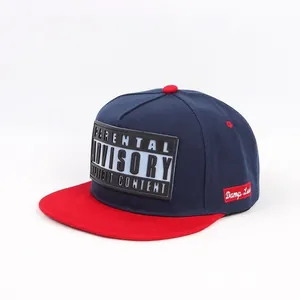 Detail view of a navy blue hip-hop baseball cap with a red flat brim and advisory patch.