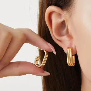 Detailed view of triple-layer gold U-shaped earrings in stainless steel on ear model