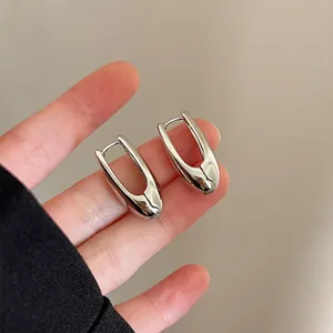 Detailed close-up view of minimalist silver teardrop hoop earrings with high-polish finish