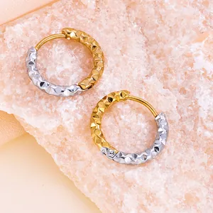 Détail rapproché de boucles d'oreilles créoles texturées bicolores en or 18K et argent