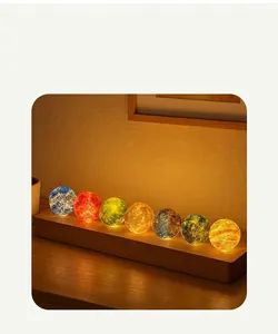 Detailed view of 7 colorful glowing crystal balls on a wooden LED base