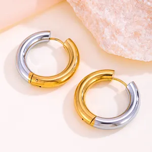Détail macro de boucles d'oreilles créoles minimalistes en or 18 carats et titane