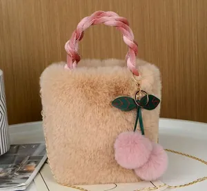 Detailansicht der flauschigen Kunstfellstruktur und des rosa Kirsch-Pompon-Anhängers.