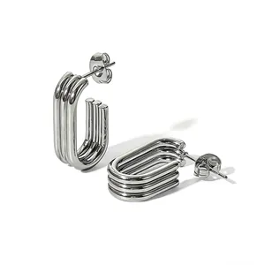 Close-up detail of triple-layered silver stainless steel U-shaped geometric earrings