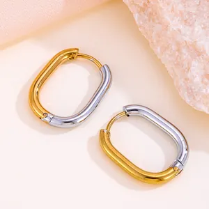 Élégantes boucles d'oreilles créoles ovales bicolores en acier titane doré et argenté.