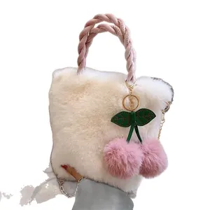 Borsa a tracolla in peluche bianca con manico intrecciato rosa e pompon ciliegia