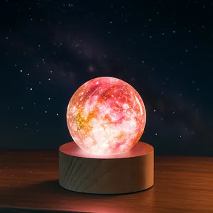 Detailed close-up view of a glowing colorful galaxy crystal ball on a round wooden base.