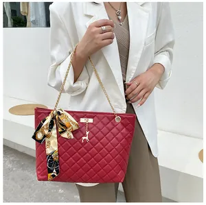 Red quilted underarm bag with gold chain strap and silk scarf bow detail on model