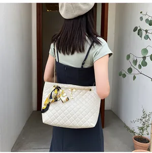 Stylish white quilted shoulder bag with gold chain strap and silk scarf accessory