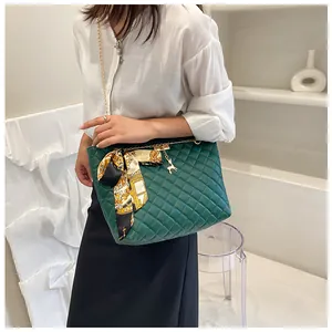 Green quilted shoulder bag with elegant silk scarf bow and gold chain strap detail