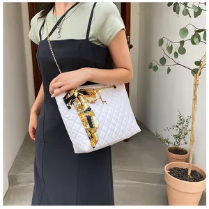 Elegant white quilted chain shoulder bag decorated with silk scarf bow and deer charm.