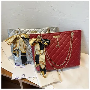 Detail view of red and silver quilted shoulder bags with silk scarf bows